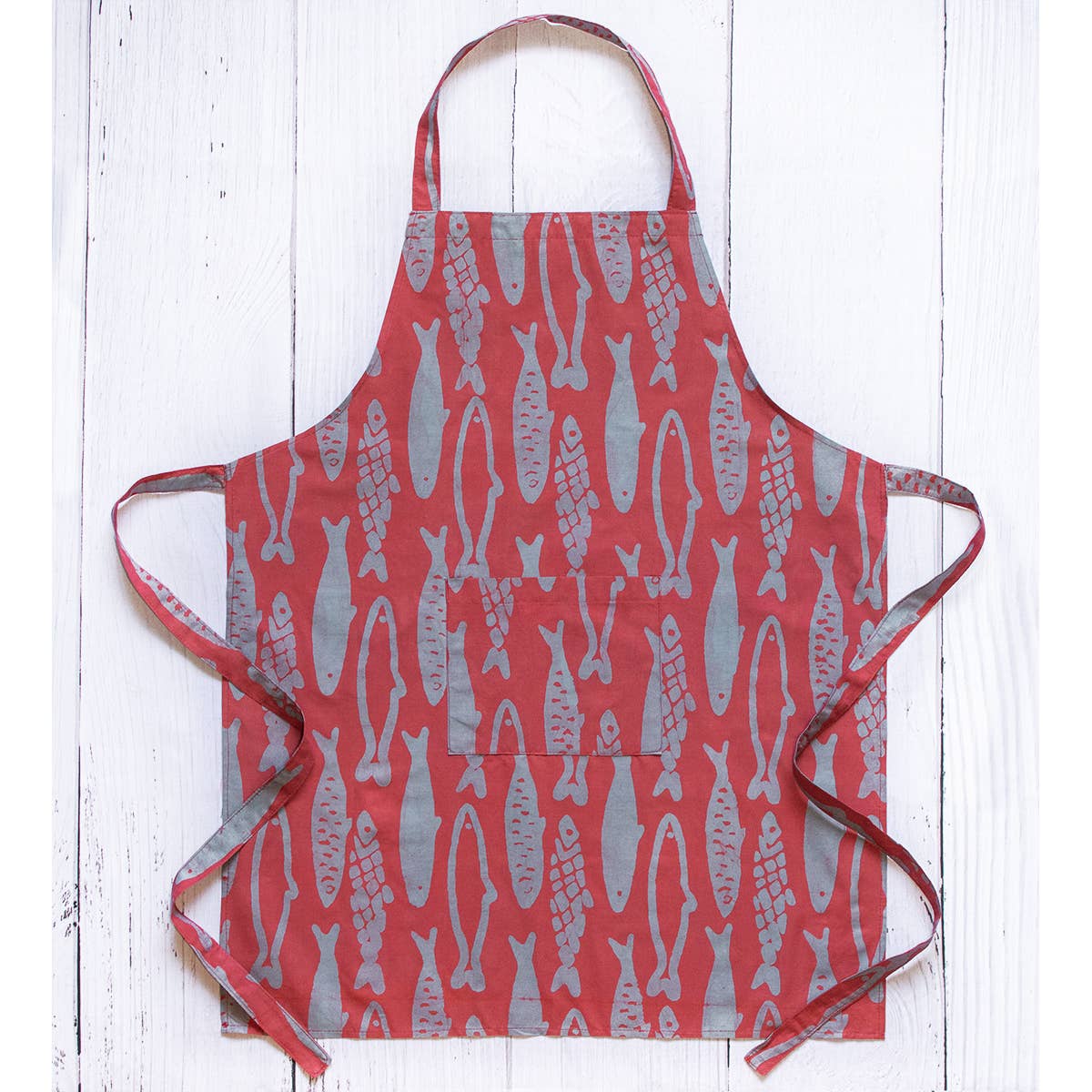 Reversible organic batik apron with sardines pattern from Global Mamas, featuring vibrant fabric and adjustable ties.