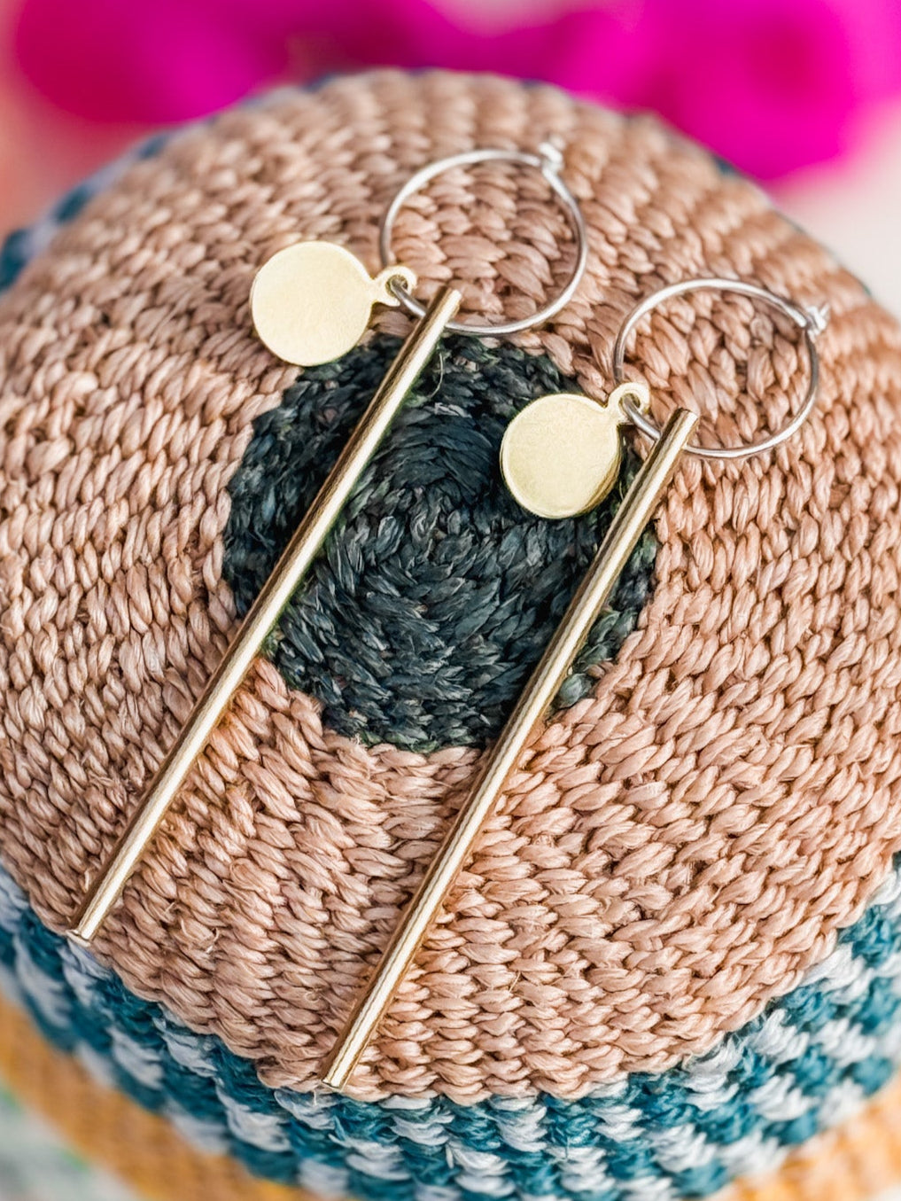Small brass disks with long rods on silver hoops