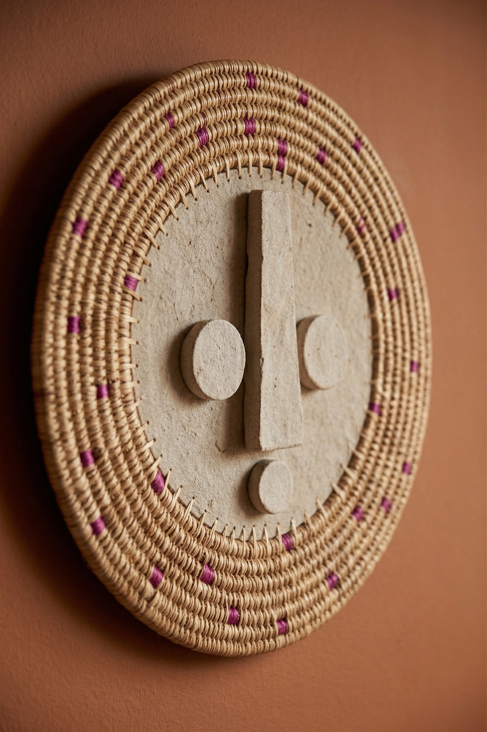 Decorative wall piece with circular design and central symbol on a brown background