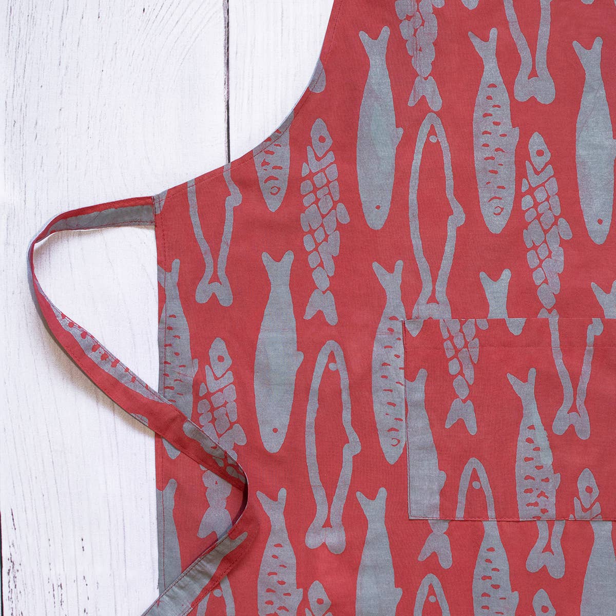 Reversible organic Batik apron with sardine pattern from Global Mamas, showcasing vibrant, handcrafted fabric and tie waist design.